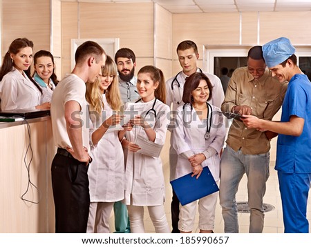 Group happy doctors standing at reception in hospital.
