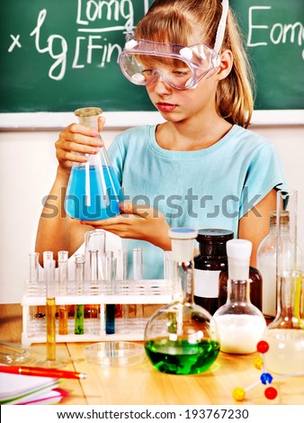 Child holding flask in chemistry class.