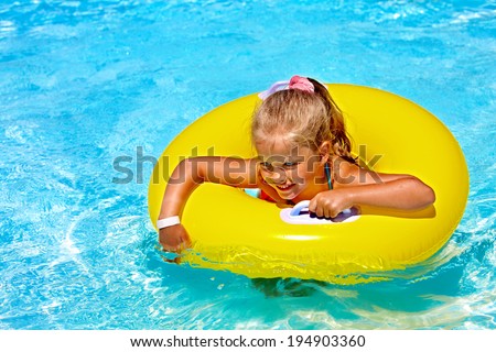 Child  on inflatable ring in swimming pool.