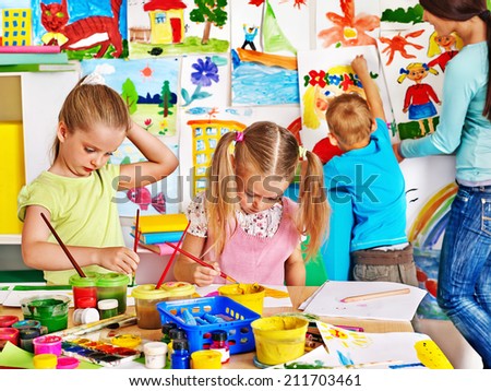 Happy children  with teacher painting.