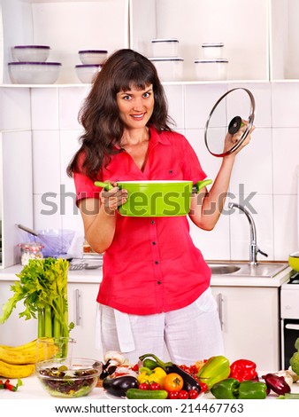 Happy woman cooking breakfast at kitchen.