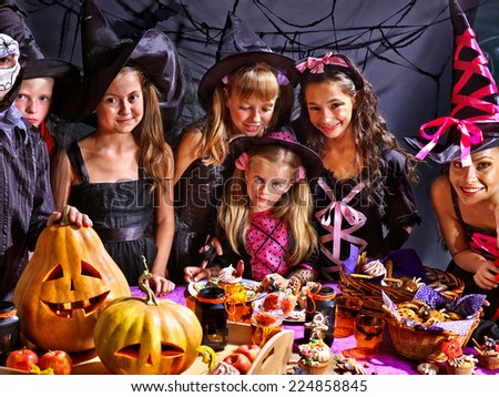 Children on Halloween party  sitting at trick or treat table.