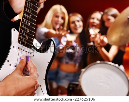 Musical group playing in night club. Body part.