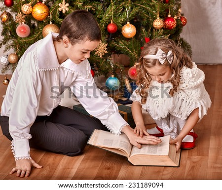 Happy children  receiving gifts under Christmas tree.