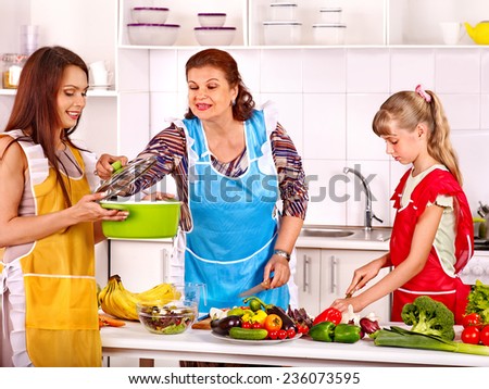 Family with grandmother and child cooking at kitchen.