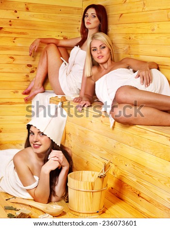 Happy girlfriends relaxing in sauna.