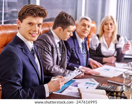 Happy group business people in office. In the foreground handsome businessman