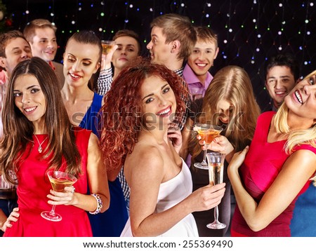 Group people with  champagne dancing at party. Girl dressed in red