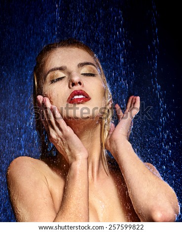 Wet woman face with water drop. Moisturizing. Dark background.