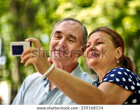 Happy old couple with camera take pictures.