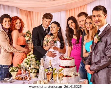 Group people at wedding table with cake.