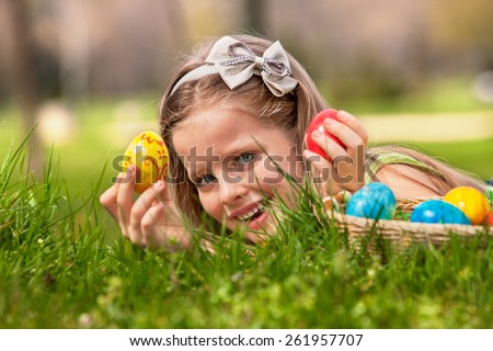 Happy child lying on green grass. and find easter egg outdoor.