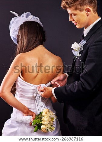 Beautiful bridal trying on wedding dress. Back view.