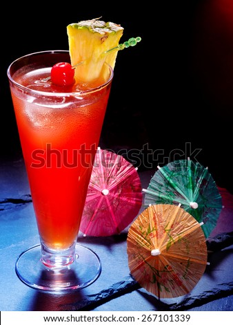 Pineapple cocktail with cherry and umbrella  in highball glass .