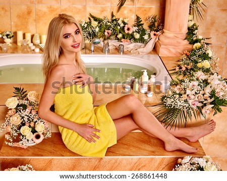 Woman relaxing at flower water spa.Yellow towel.
