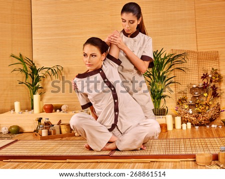 Young woman getting thai herbal massage ball. Girl sitting.