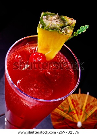 Pineapple red  cocktail with cherry and umbrella in highball glass . Top view.