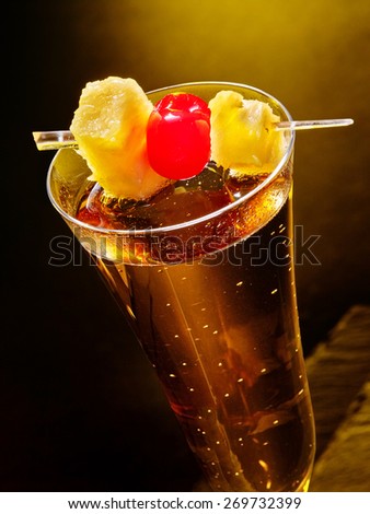 Champagne  cocktail with cherry and pineapple in highball glass . Top view.