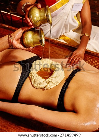Young woman having stomach Ayurveda spa treatment. Treatment of lumbar.