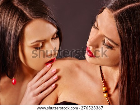 Two kissing women .Kiss on shoulder.
