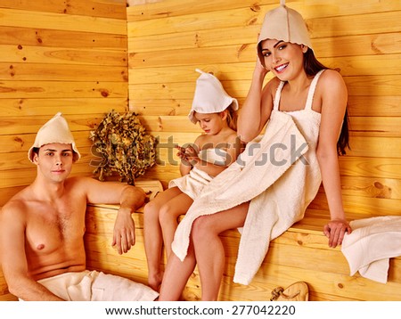 Family of three persons in hat  relaxing at sauna.