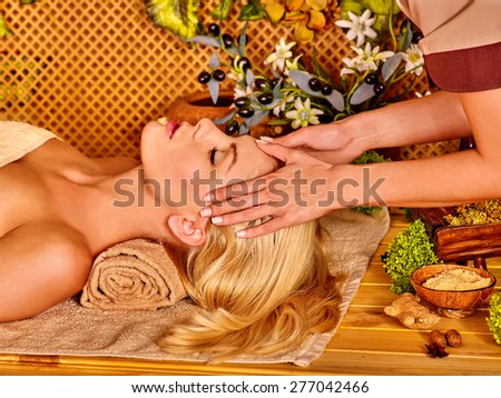 Woman getting facial massage in tropical spa. Hands on forehead