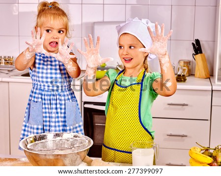 Child with rolling-pin dough at kitchen. Messy kids