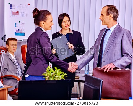 Happy business people in office. Man handshake woman.