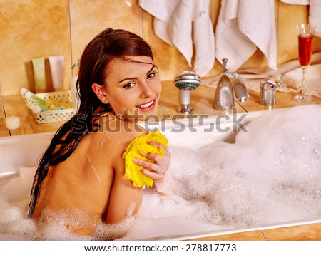 Young woman take bubble  bath. Home interior.