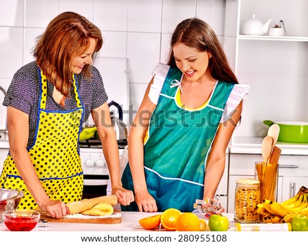 Mother and daughter cooking and talking food at kitchen.