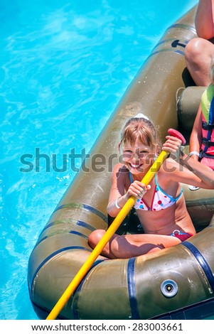Family ride rubber boat in water park.