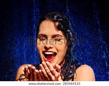 Wet woman face with water drop. Moisturizing on black background.
