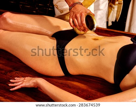 Young woman having stomach Ayurveda spa treatment.