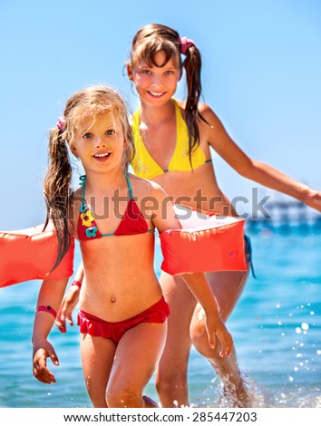 Little girl  playing on  beach on sky background.