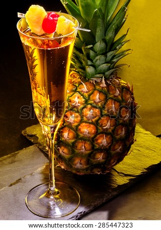 Champagne  cocktail with cherry and slice of pineapple in highball glass . Cocktail card 61
