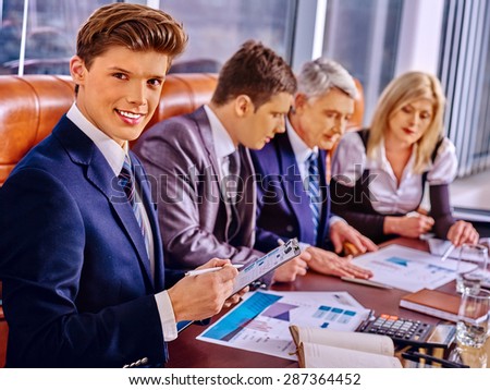 Happy group business people in office. In the foreground handsome businessman nice smiling