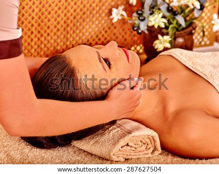 Woman getting head massage in tropical beauty spa. A lot of flower.