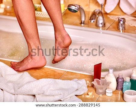 Female  bare feet in bubble bath. Skincare .