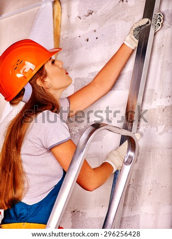 Happy working woman in builder uniform indoor.