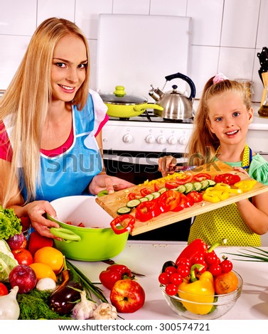 Mother and daughter cooking food at kitchen.