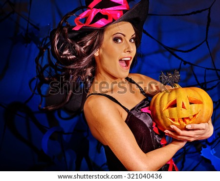 Happy beauty witch holding pumpkin