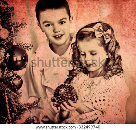 Children sister and brother decorate on Christmas tree. Black and white retro.