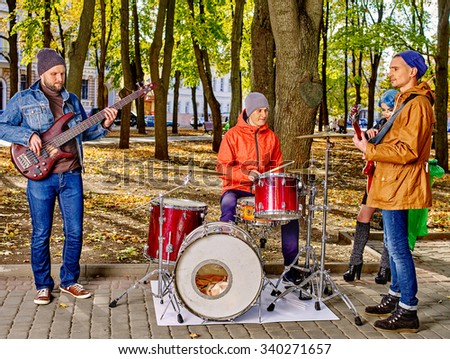 Music street men performers on park autumn outdoor.