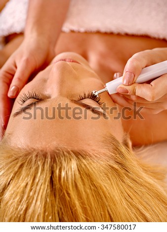 Close up of  woman close up  receiving electric facial eyes massage on microdermabrasion equipment at beauty salon.