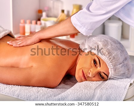 Groomed woman middle-aged take back massage in spa salon with young beautician.