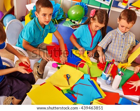 Children working with colored paper on table in kindergarten .Creative development of children.