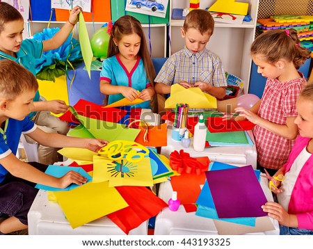 Group kids holding colored paper on table in kindergarten . Children writting letter Santa Claus.
