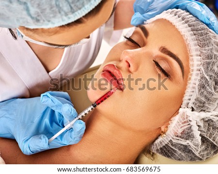 Filler injection for female forehead face. Silicone lips in the girl. Doctor in medical gloves with syringe injects lips augmentation. Plastic surgery is progressing.