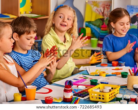 Small students with teacher finger painting in art school class. Break school in painting class. Mom and kids at home. Craft drawing education develops creative abilities of children. Children indulge