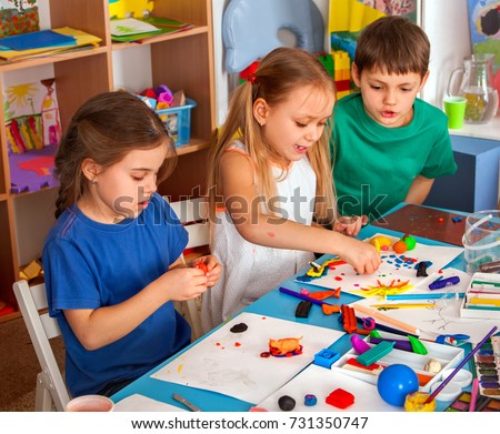 Child dough play in school. Plasticine for children. mold from plasticine in kindergarten. Kids knead modeling clay with hands in preschool. Zoo from plasticine. They learn to live in a team.